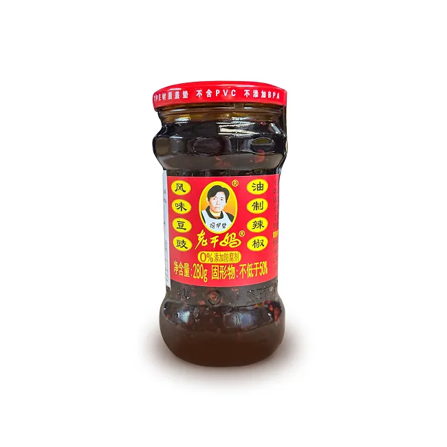 Un pot en verre avec une étiquette rouge d'un produit chinois dont la marque est représentée par le visage et tablier de la cuisinière.